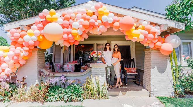 couple throws walk by baby shower, the front of their house decorated with lots of balloons