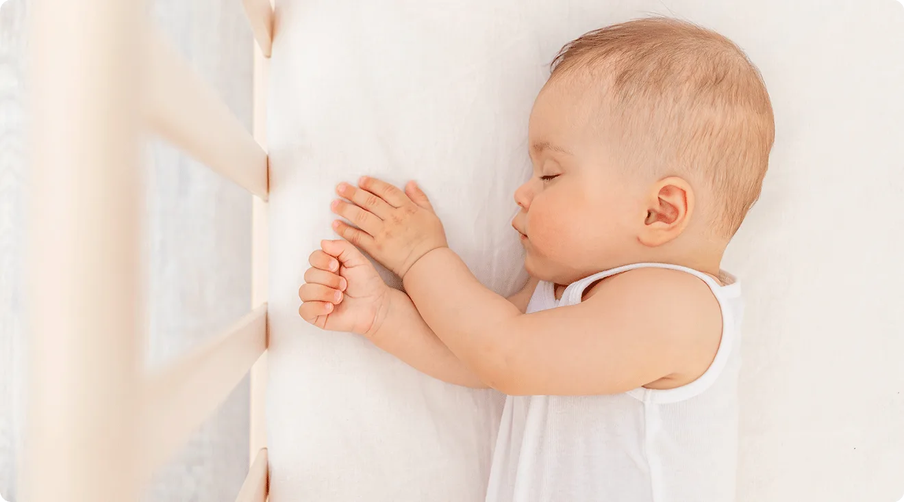 5 month old baby taking a nap in crib