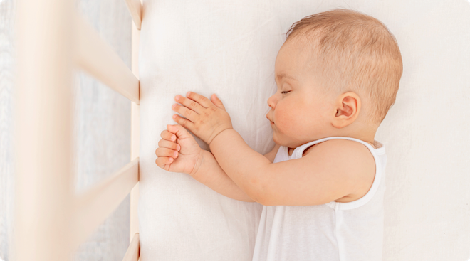 5 month old baby taking a nap in crib