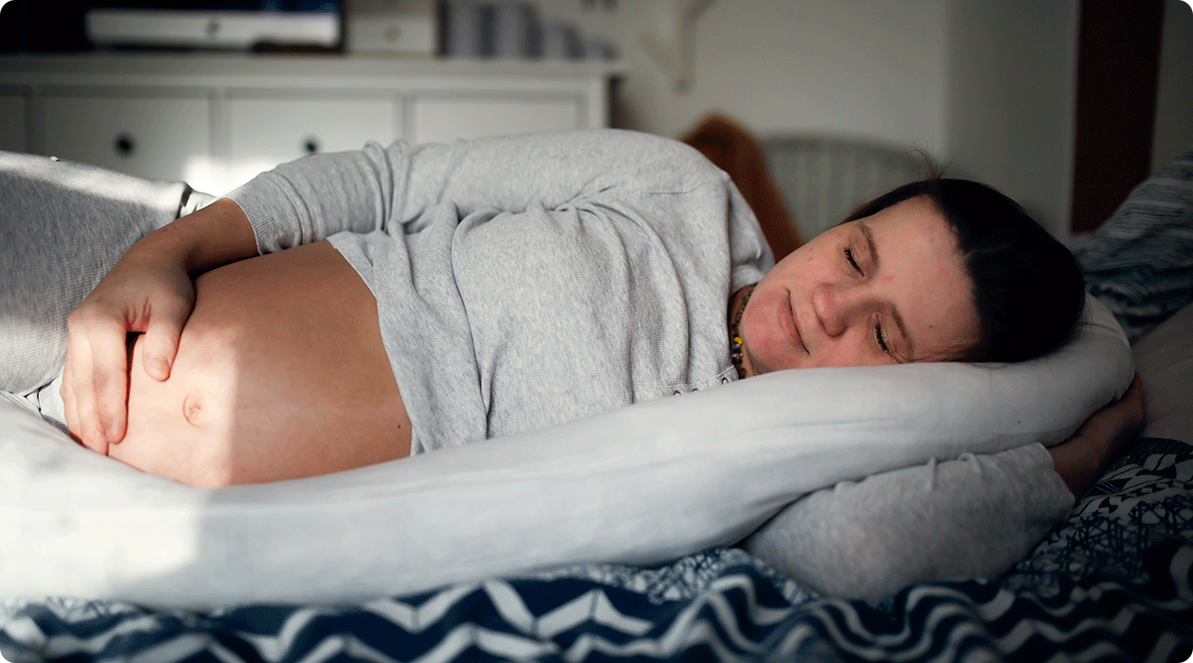 pregnant woman sleeping in bed