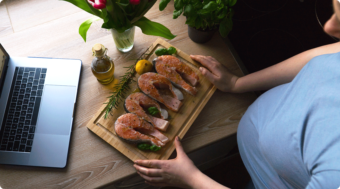 pregnant woman preparing salmon