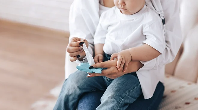 mother pulling out baby wipes with child sitting on lap