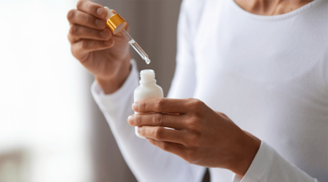 woman holding bottle of retinol skincare serum