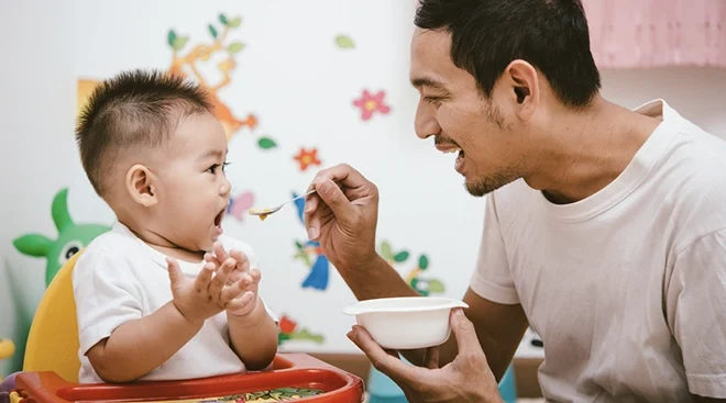 father feeding baby cereal 