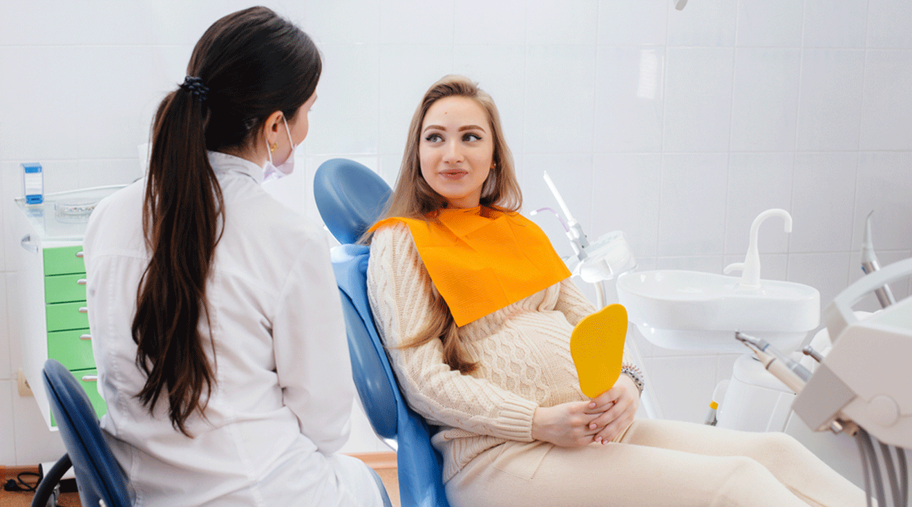 pregnant woman talking to dentist