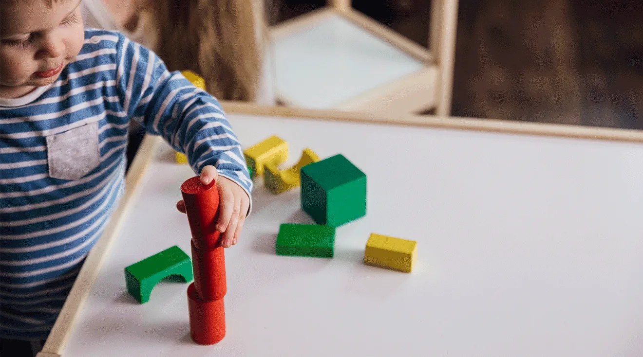baby using the pincer grasp while playing with block toys