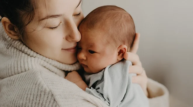 mother cuddling newborn baby