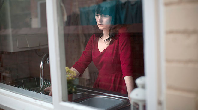 nervous woman stands by window