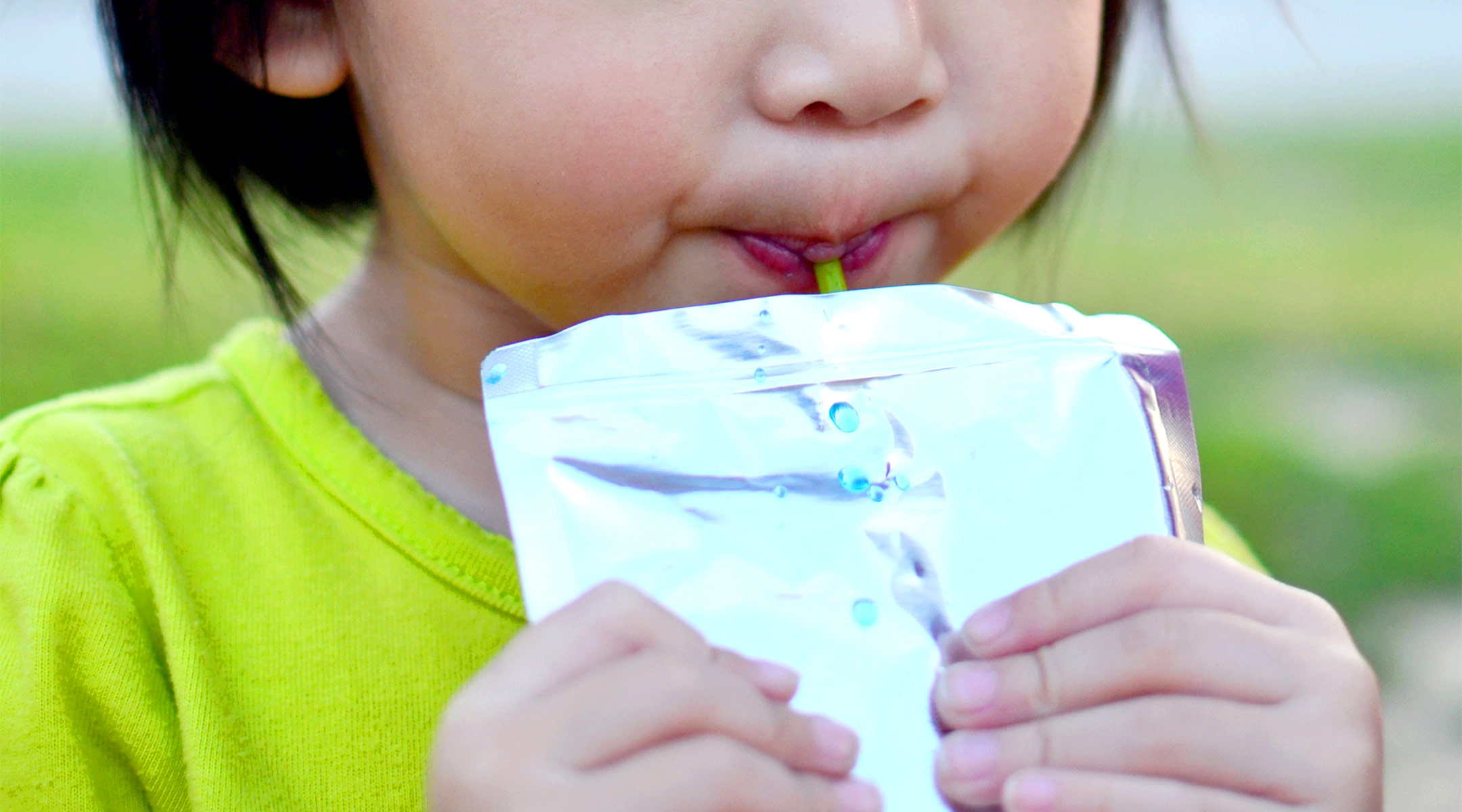 toddler drinking from juice pouch