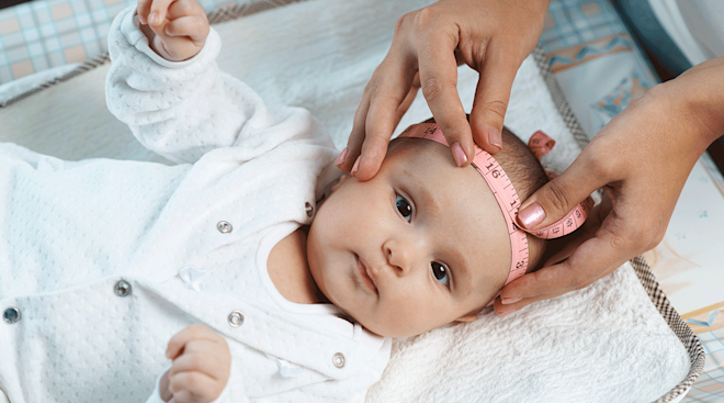 Measuring the head circumference of a newborn