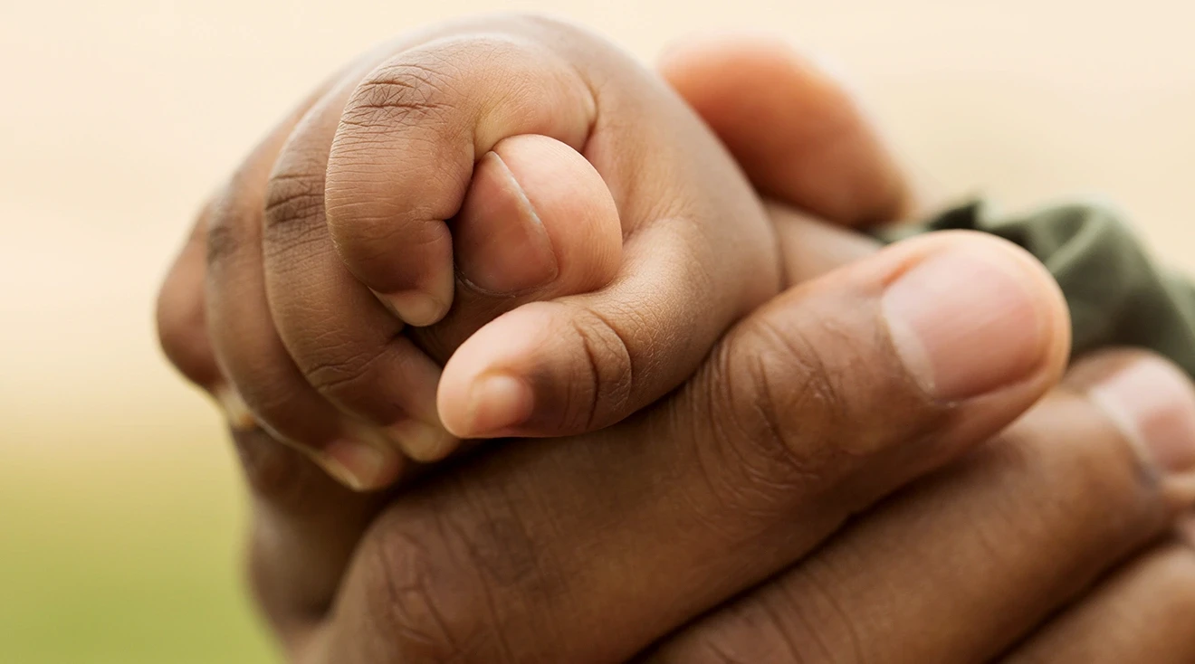 close up of father holding child's hand