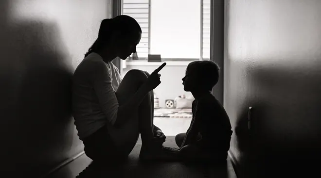 black and white image of mother disciplining toddler