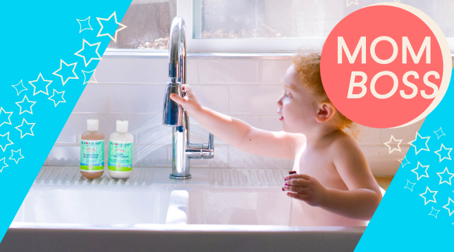 toddler in kitchen sink using california baby products