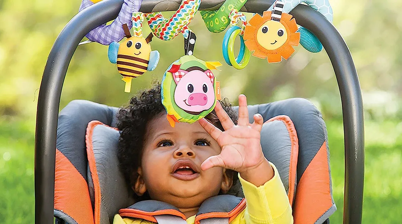 Baby playing with a stroller toy