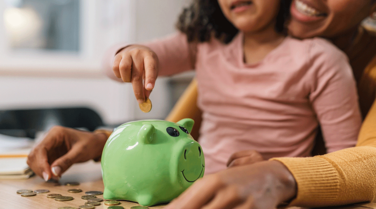 mom and child putting coins into piggy bank