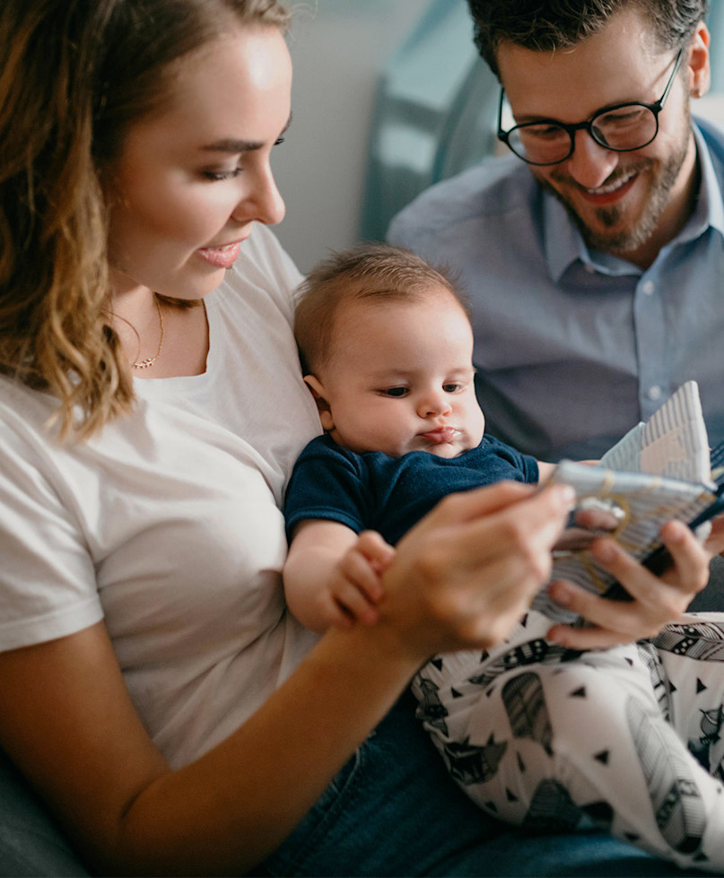 parents reading night time story to baby