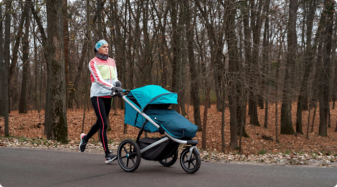 mom jogging with stroller outside