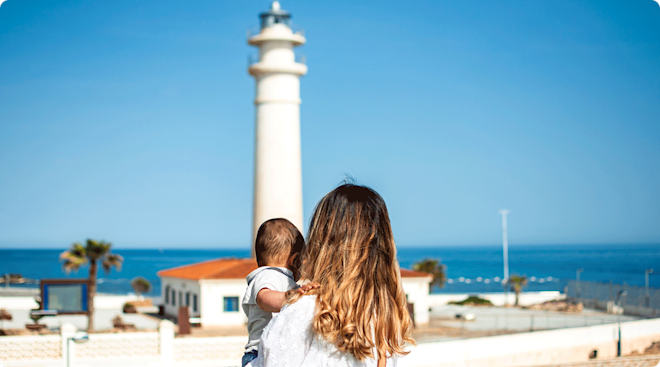mom and baby with lighthouse in the background