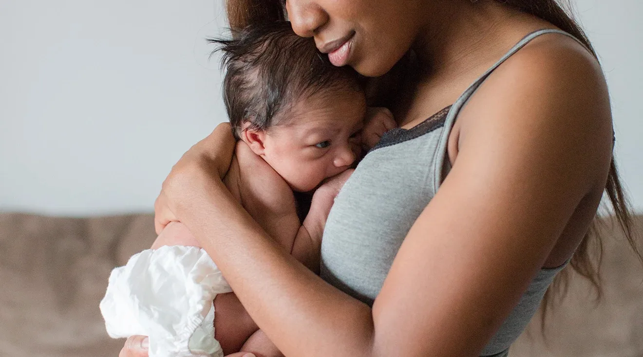 mother holding and cuddling newborn baby