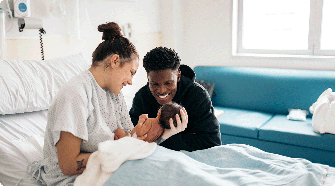 parents with their newborn baby in maternity hospital labor and delivery recovery room