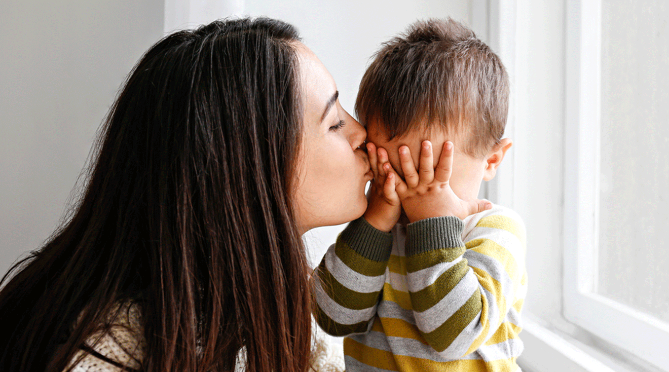 mom kissing sad toddler