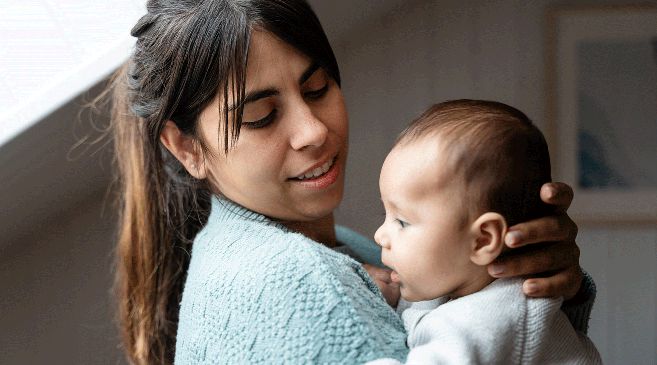 new mom holding newborn baby at home