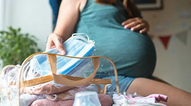 pregnant woman packing hospital bag during pandemic