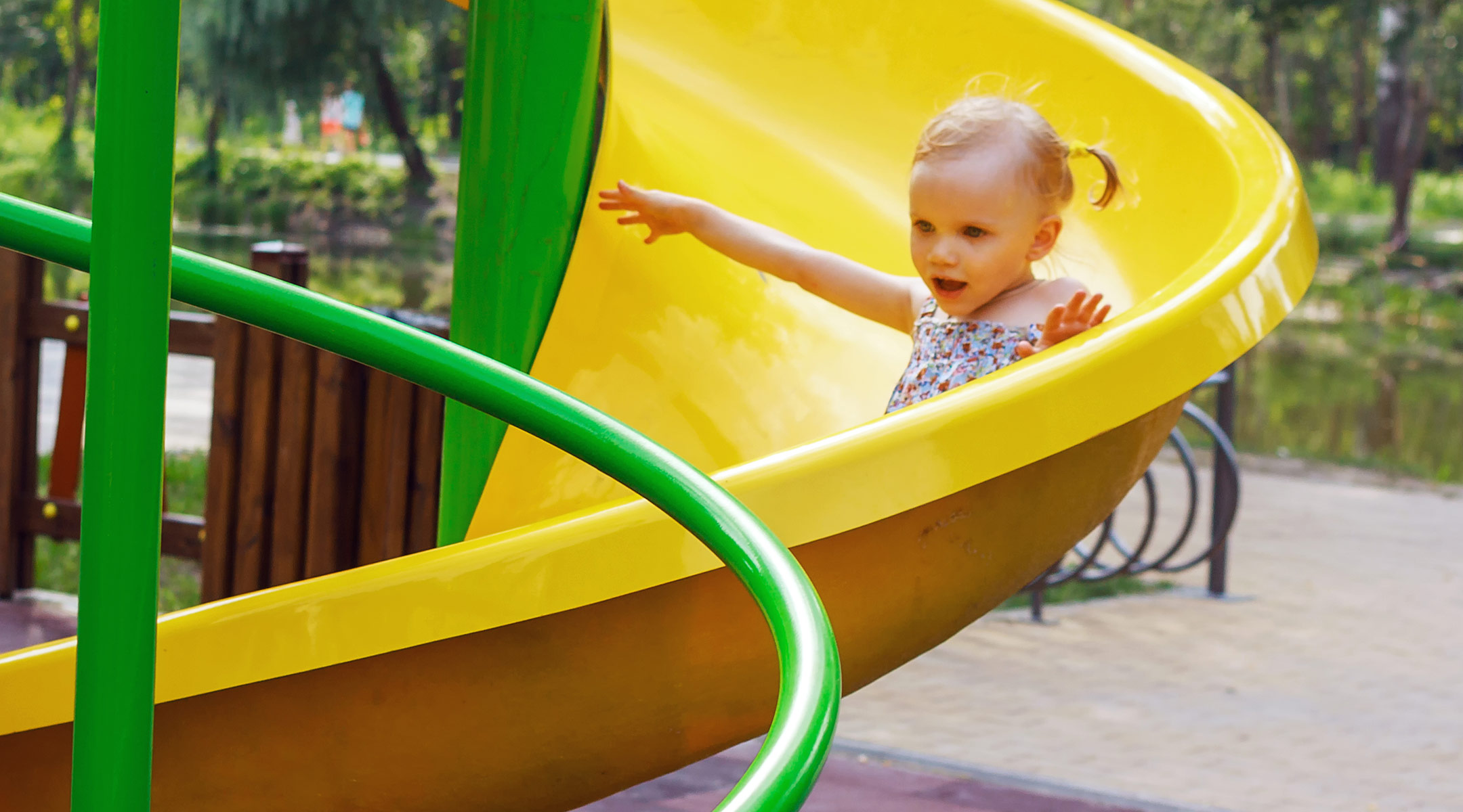 little girl sliding down slide at playground