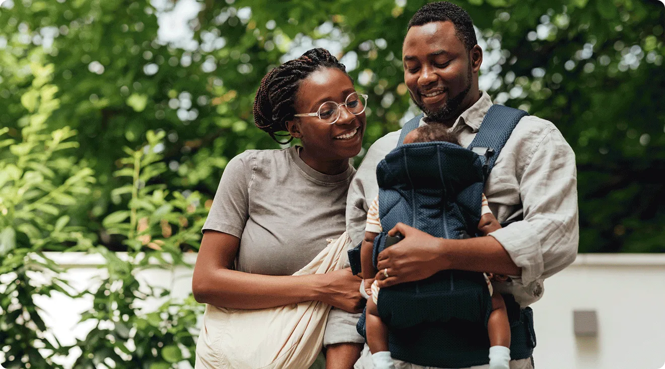 couple walking outside with baby in carrier