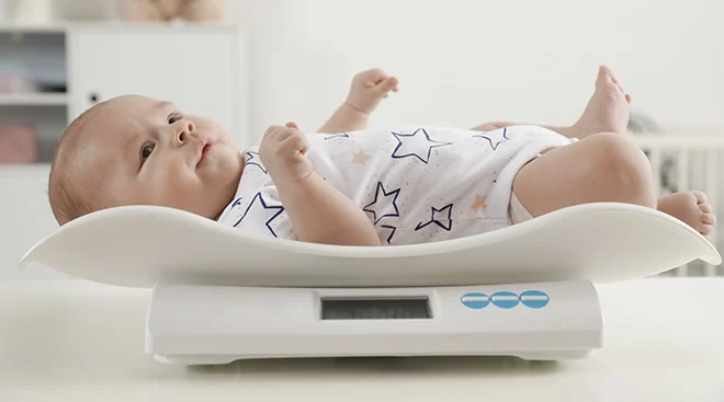 baby lying on weight scale