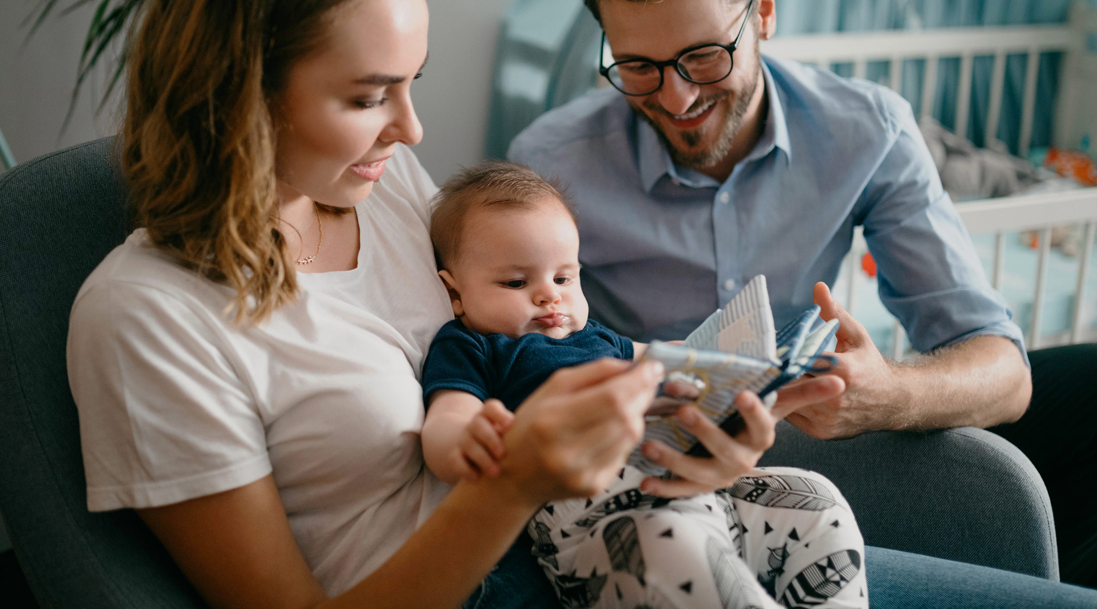 parents reading night time story to baby