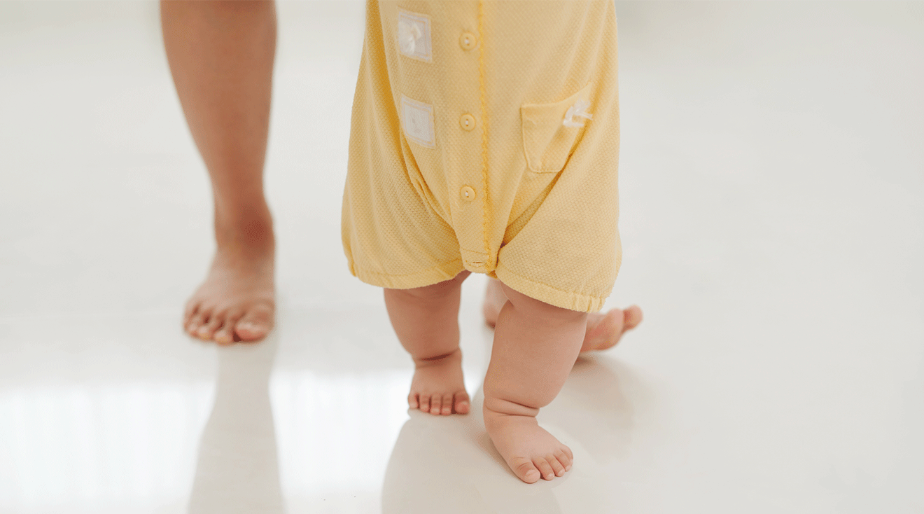 mother teaching baby how to walk