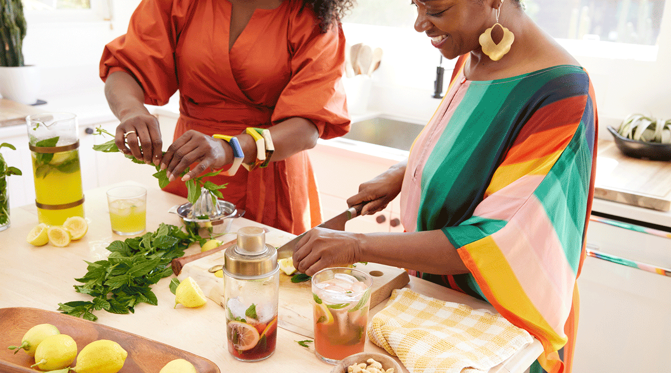 two women making mocktails in kitchen at home
