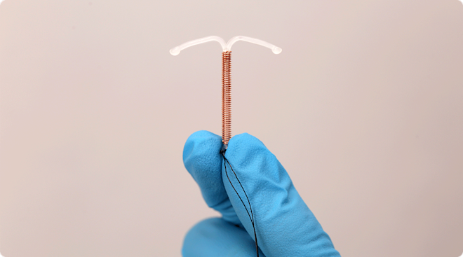 hand with medical glove holding IUD