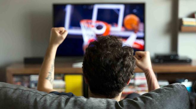 man at home watching basketball