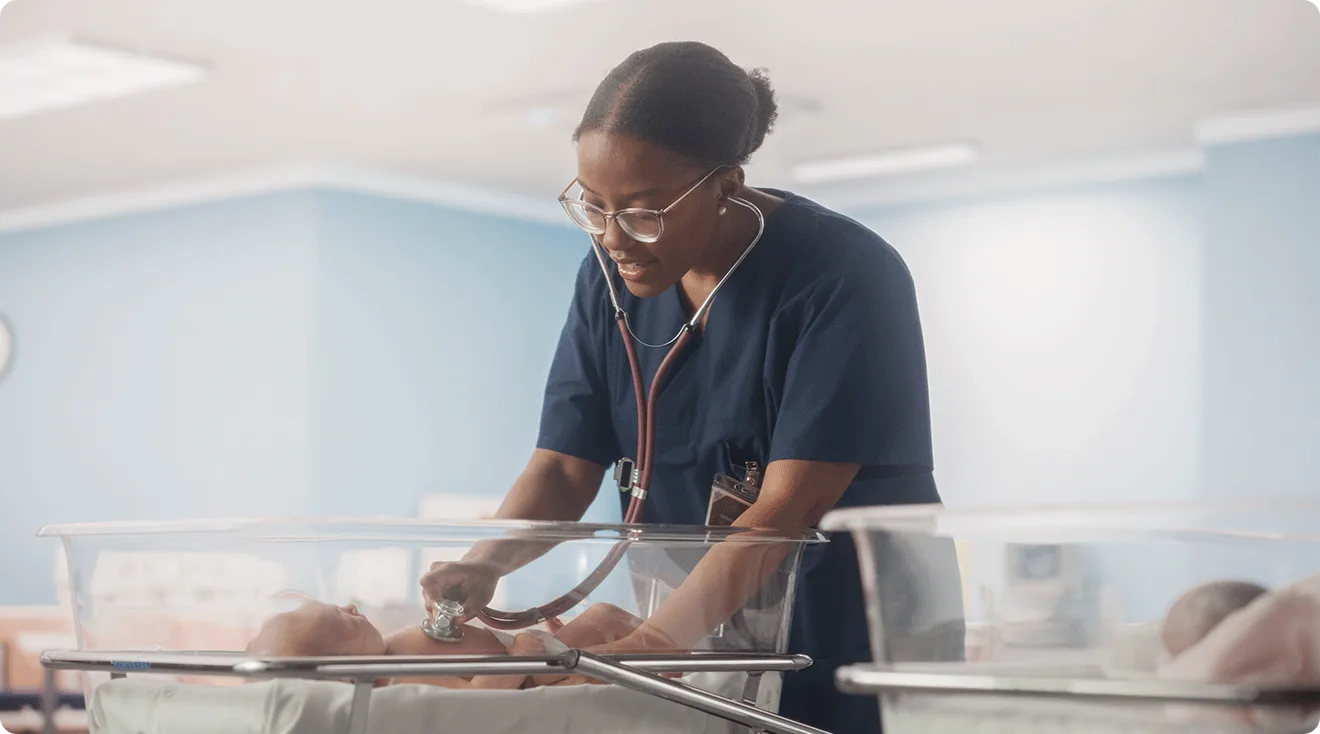 nurse caring for newborn baby in hospital nursery
