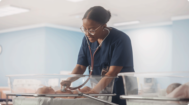 nurse caring for newborn baby in hospital nursery