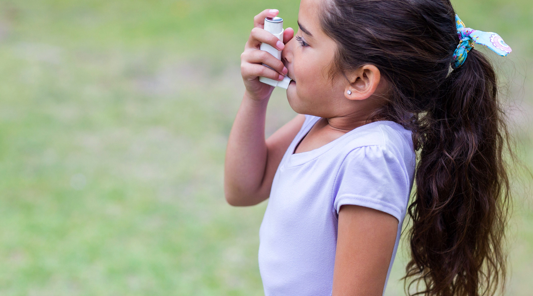 little girl using asthma inhaler 