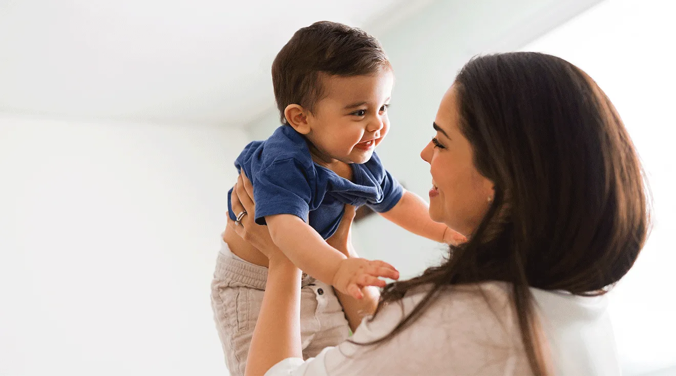 mother holding toddler smiling