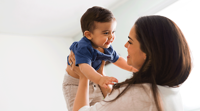 mother holding toddler smiling
