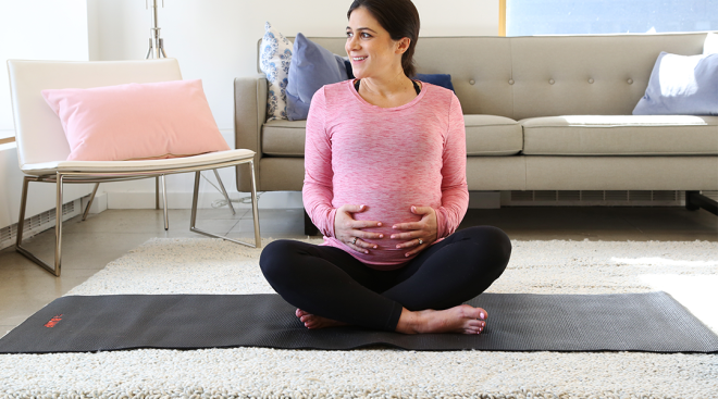 pregnant woman smiling and doing exercise at home