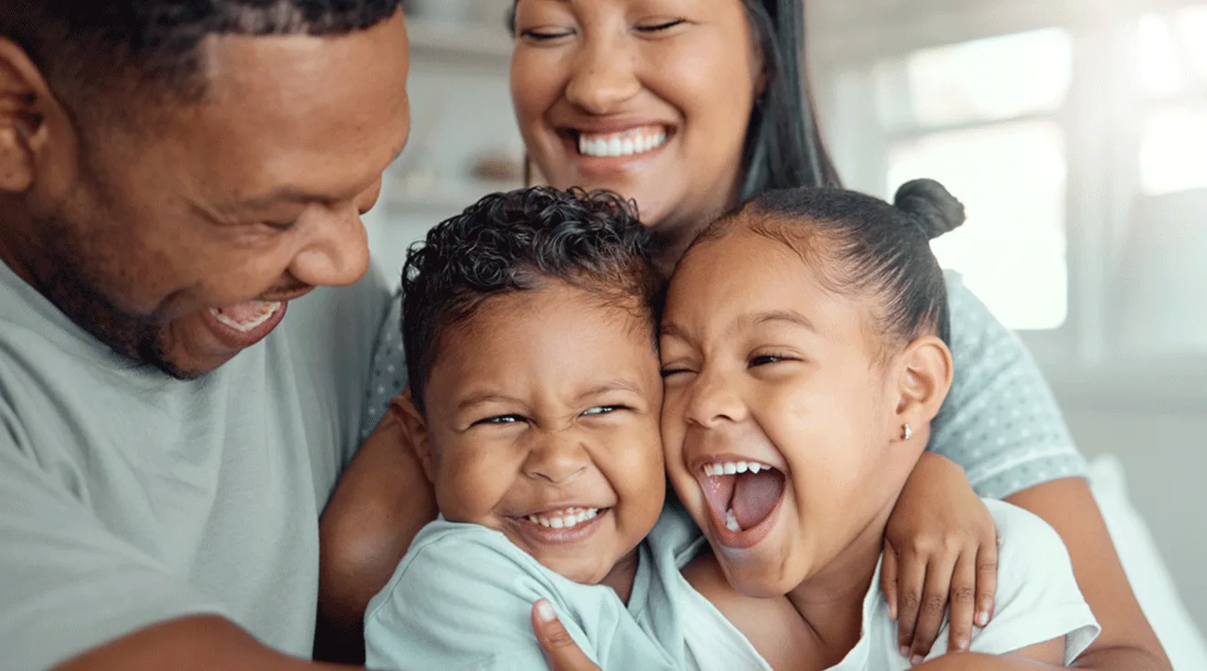 mom and dad laughing with their son and daughter