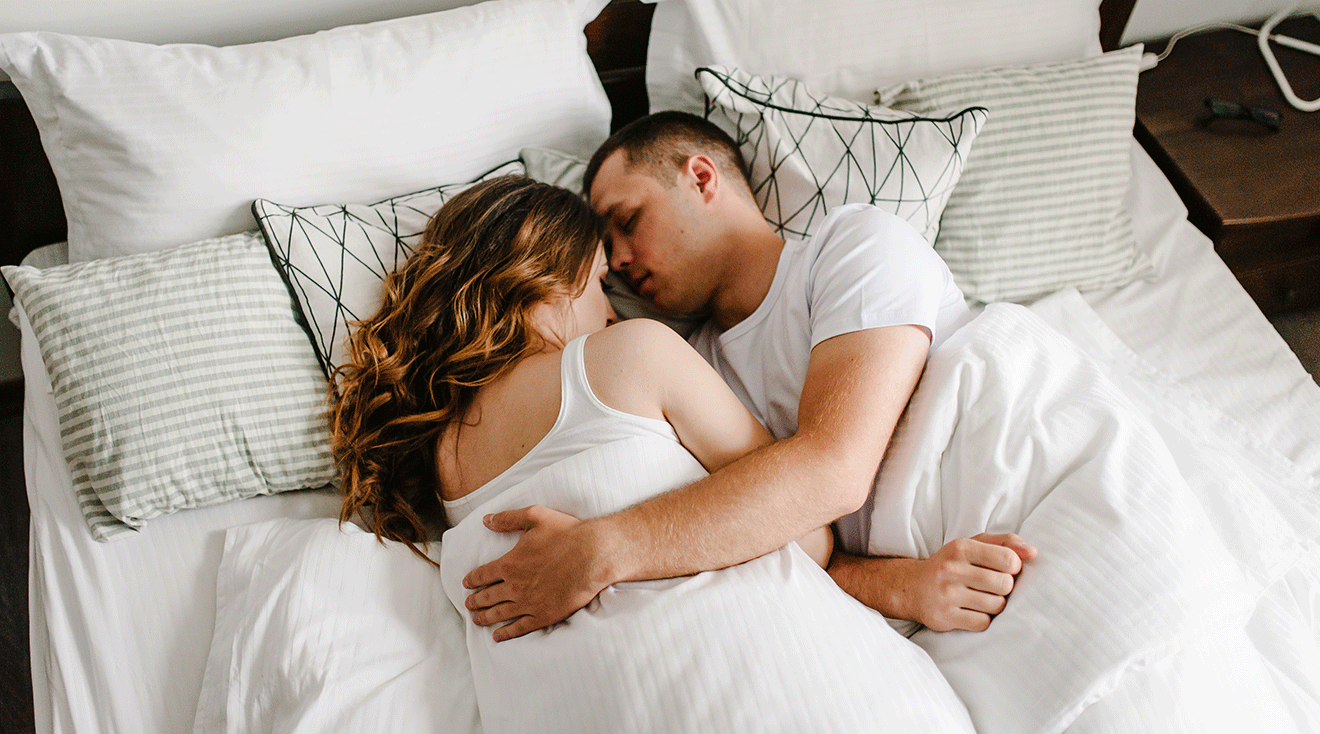 couple cuddling in bed at home