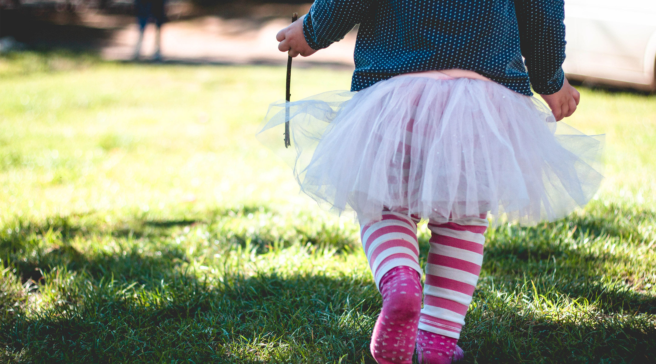 little girl walking outside in pink tutu