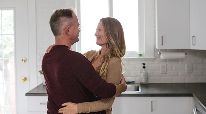 middle aged couple embracing in kitchen at home