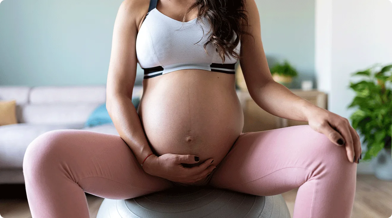 pregnant woman sitting on yoga exercise ball