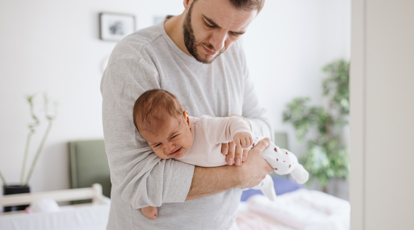 dad holding crying baby