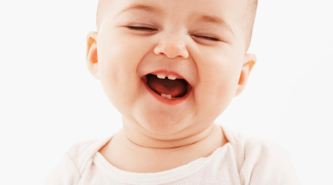 baby smiling showing newly grown teeth