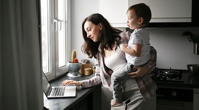 mother holding baby while shopping online