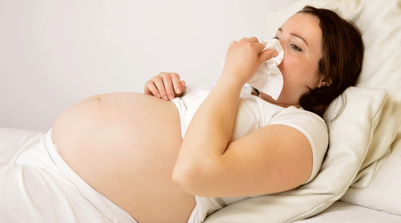 pregnant woman blowing nose